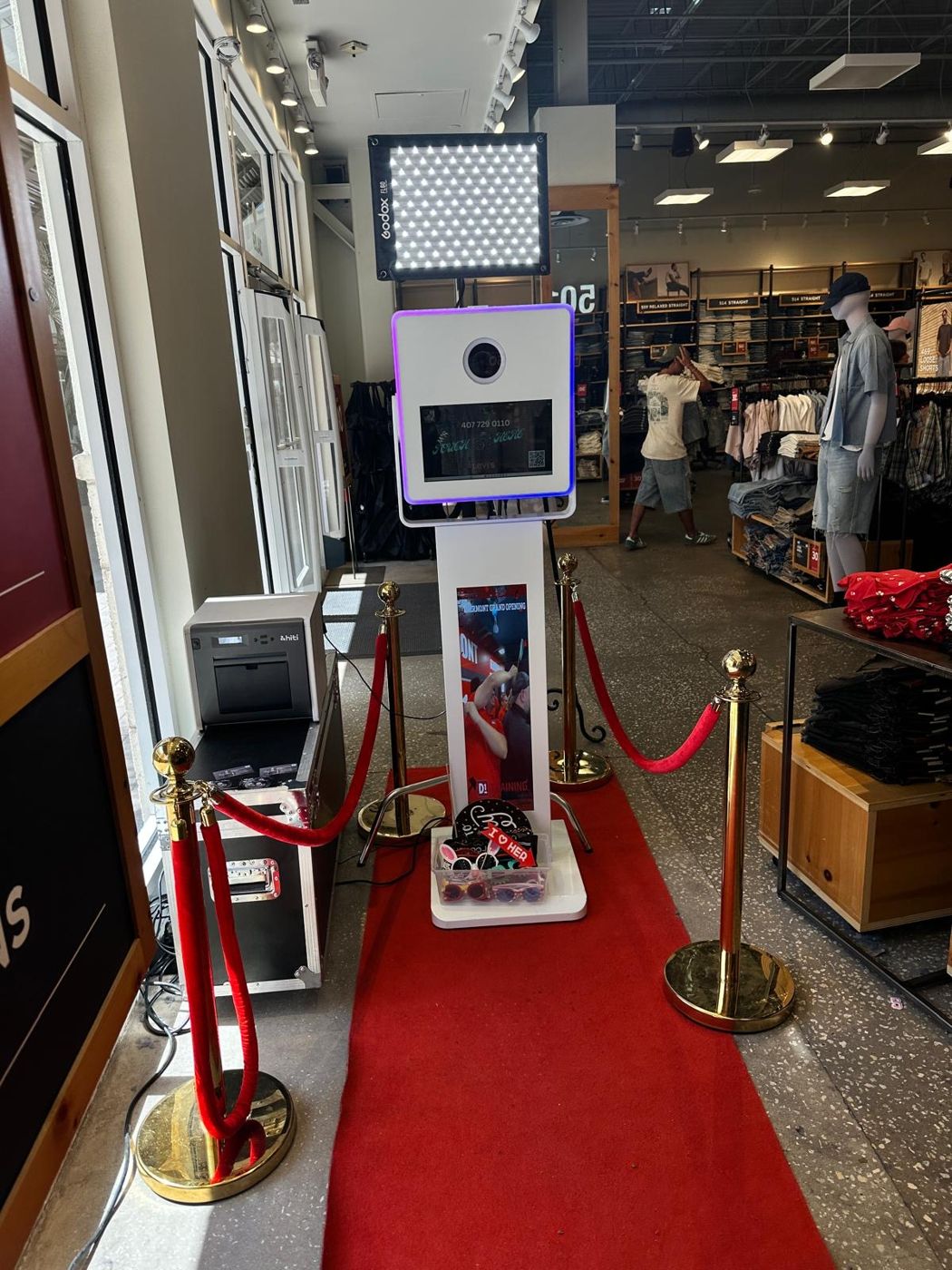 M'S 360 photo booth at a retail grand opening with red carpet and printer